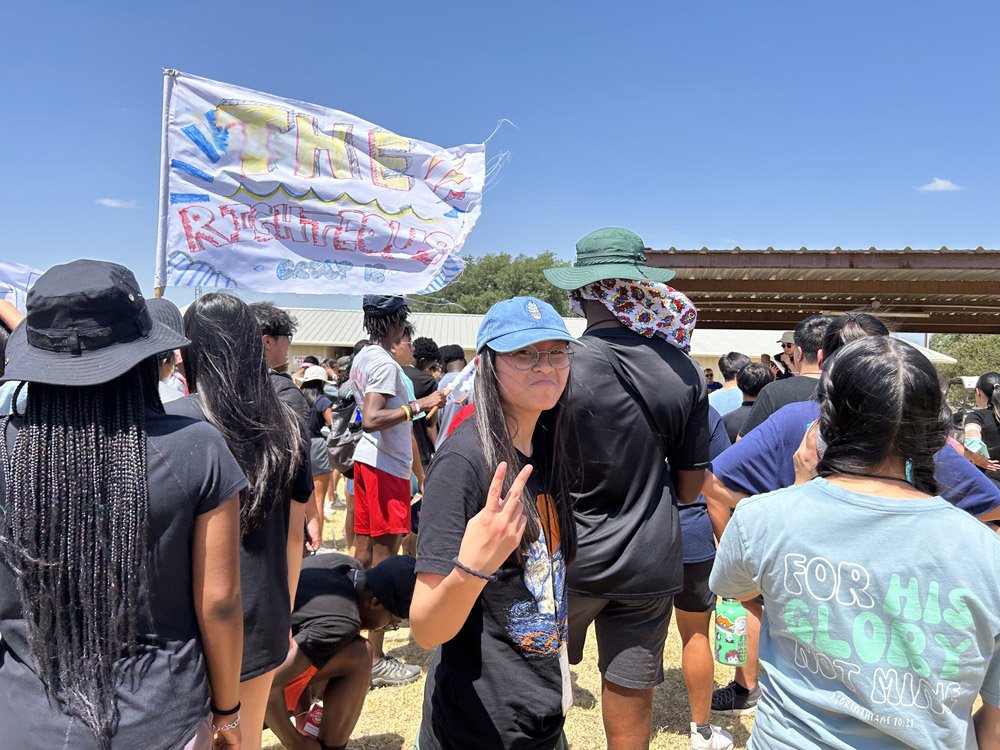Students with a hand-painted group banner at an outdoor retreat